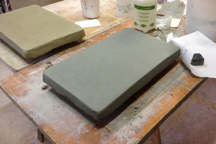 Handwerkliche Herstellung eines Tadelakt-Musters: Musterplatte mit verdichteter, polierter Kalkputzoberfläche