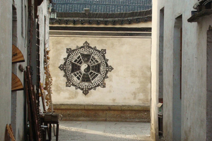 Das Bild zeigt das Wandbild eines Baguas auf einer Mauer in einem alten chinesischen Dorf in der Gegend von Suzhou.