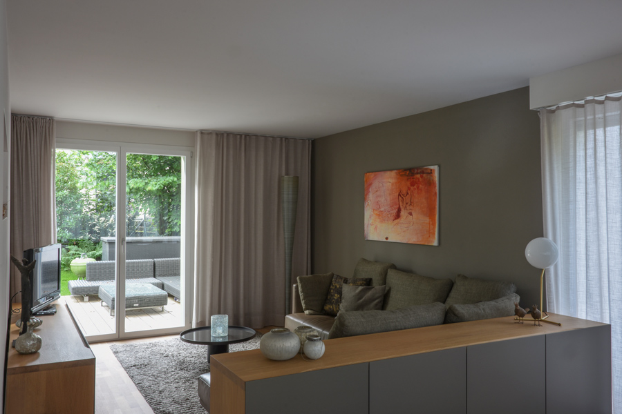  Farbgestaltung Innenraum: Das Bild zeigt einen ruhigen Wohnbereich mit Ausblick auf die Gartenterrasse.