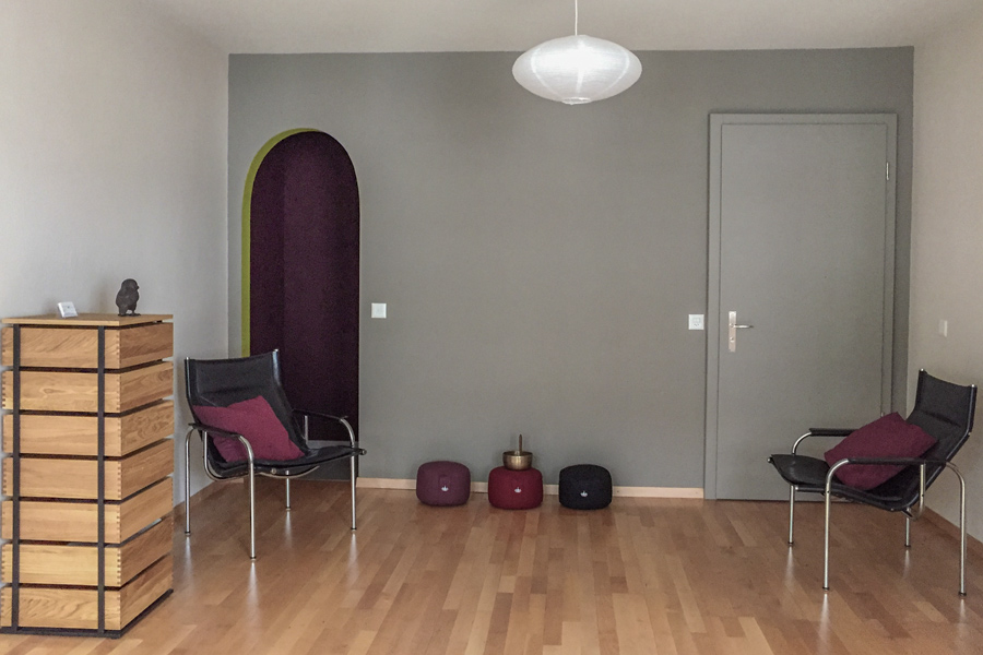 Farbgestaltung Praxisraum: Das Bild zeigt die Eingangswand in mittlerem Umbraton und links den auberginefarbigen kleinen Nebenraum.